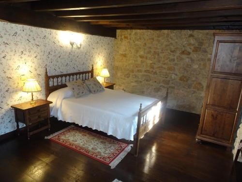 ein Schlafzimmer mit einem Bett, zwei Lampen und einer Tür in der Unterkunft LA CASONA DE ESCALADA in Escalada