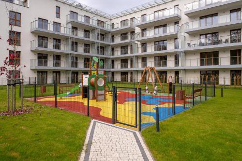 a playground in front of a large apartment building at RentPlanet - Apartamenty Zakopiańskie in Zakopane