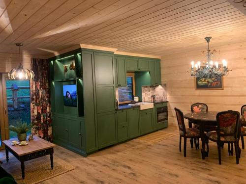 a dining room with green cabinets and a table at Apartament Zielony by Homeprime in Bukowina Tatrzańska