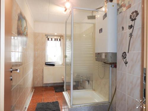 La salle de bains est pourvue d'une douche avec une porte en verre. dans l'établissement Wohnung nähe Daimler 1 OG, à Brême