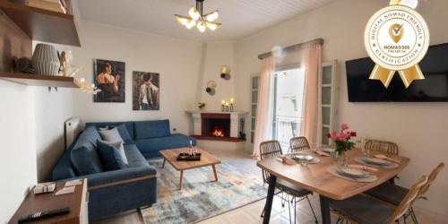uma sala de estar com um sofá azul e uma mesa em Dolce Favola Nomad Casa - Kalamata's City Getaway em Kalamata