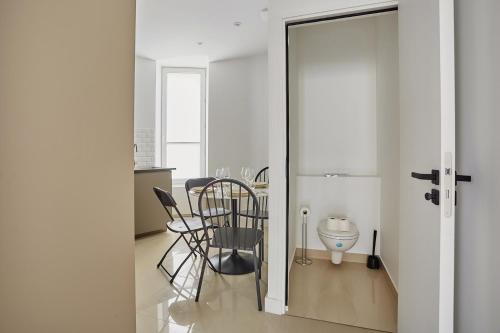 d'une salle à manger avec une table, des chaises et une porte en verre. dans l'établissement Apartment center of Paris by Studio prestige, à Paris