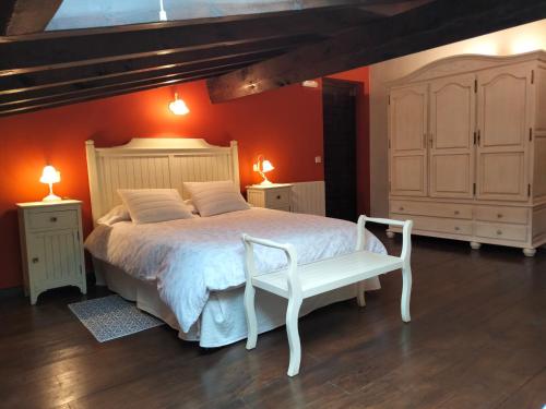 a bedroom with a white bed and a white chair at LA CASONA DE ESCALADA in Escalada