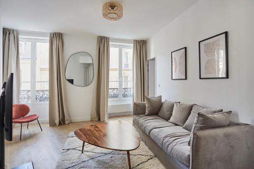 un salon avec un canapé et une table dans l'établissement Apartment center of Paris by Studio prestige, à Paris