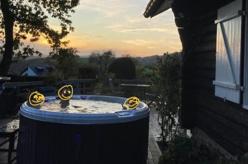 a hot tub with four yellow dials in a yard at Le chalet de Roanne-Coo in Stoumont