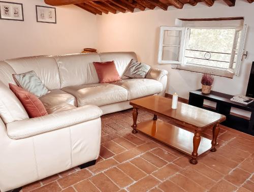 Sala de estar con sofá blanco y mesa de centro en Alba - Villa Cenami - grande PISCINA con vista, en Massarosa