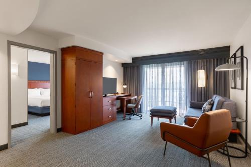 una camera d'albergo con letto e soggiorno di Courtyard by Marriott Madison West / Middleton a Middleton