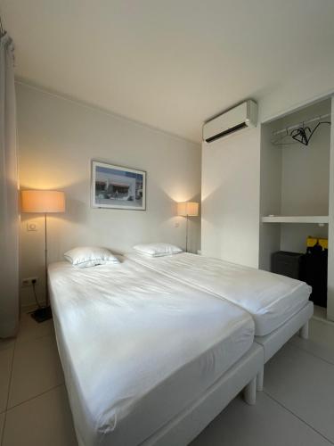 une chambre avec un grand lit blanc avec deux oreillers dans l'établissement Renovated Cannes Centre Banane balcon, à Cannes