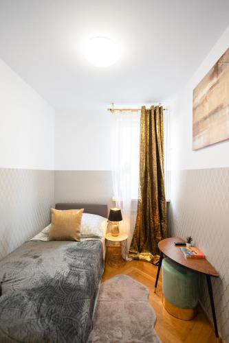 ClickTheFlat Stawki Apart Rooms في وارسو: غرفة نوم بسرير وطاولة ونافذة