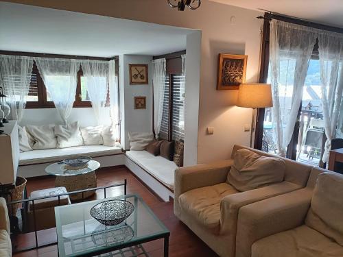 a living room with a couch and a table at Junto a Vielha Apartamento Gausac in Gausach