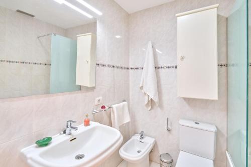 een witte badkamer met een wastafel en een toilet bij VENTANA AL ATLANTICO in El Médano