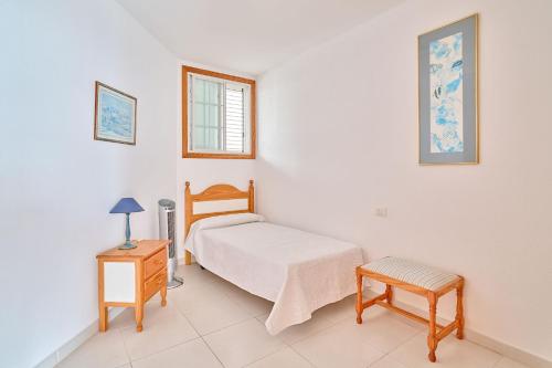 een slaapkamer met een bed, een tafel en een stoel bij VENTANA AL ATLANTICO in El Médano