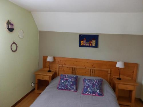 un dormitorio con una cama con dos almohadas. en Le coucou, en Breitenau