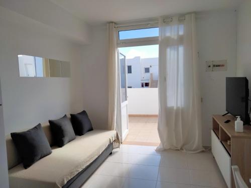 a white living room with a couch and a television at Mirador de Sotavento apartment 27 A in Costa Calma