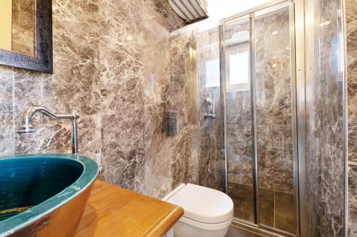 a bathroom with a tub and a toilet at Bramasole Alaçatı Butik Hotel in Alacati