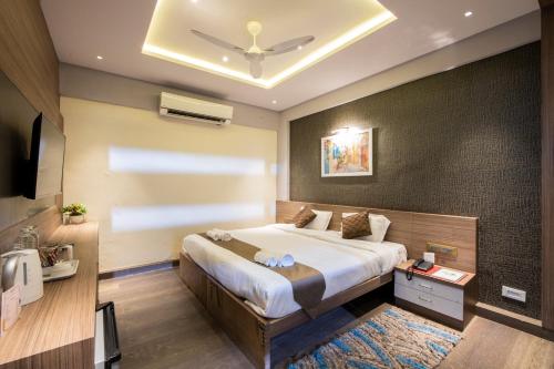 a bedroom with a large bed and a ceiling at Area 37 in Pune