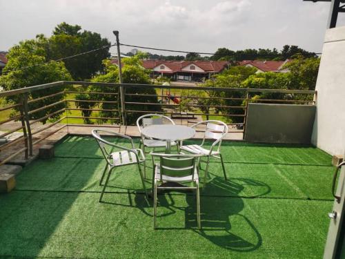 d'une table et de chaises sur un balcon avec pelouse dans l'établissement DAlyaHomestay, à Malacca