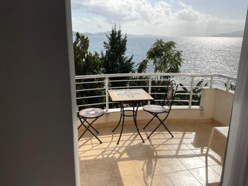 balcón con mesa, sillas y vistas al océano en Mojito Beach Apartments with Free Parking, en Sarandë