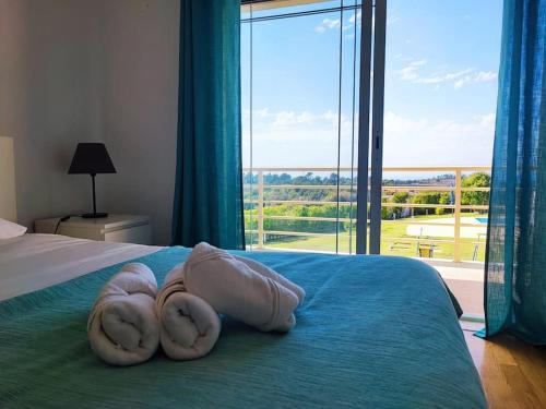 una camera da letto con un letto con una grande finestra di Zambujal Sun a Sesimbra