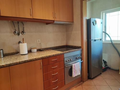 a kitchen with a stove and a refrigerator at Zambujal Sun in Sesimbra