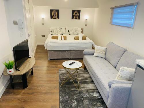 a living room with a couch and a bed at Buckinghamshire Elegant Studio in Buckinghamshire