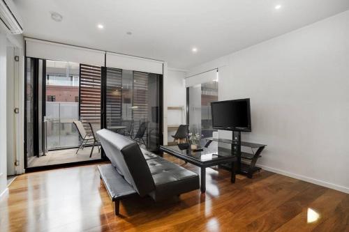 sala de estar con sofá y TV en Beachfront Bliss: Luxury Living en Geelong