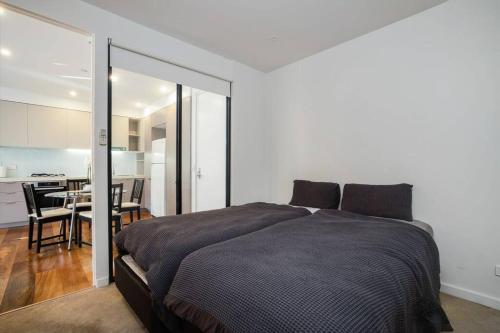 1 dormitorio con 1 cama grande y cocina en Beachfront Bliss: Luxury Living en Geelong