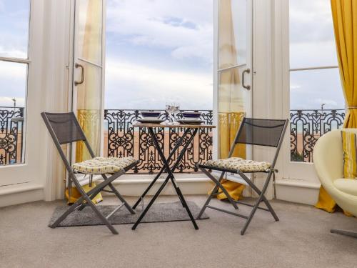 two chairs and a table on a balcony with windows at The Old Spy Headquarters in Folkestone