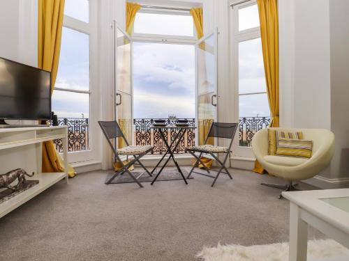 a living room with a tv and chairs and a balcony at The Old Spy Headquarters in Folkestone