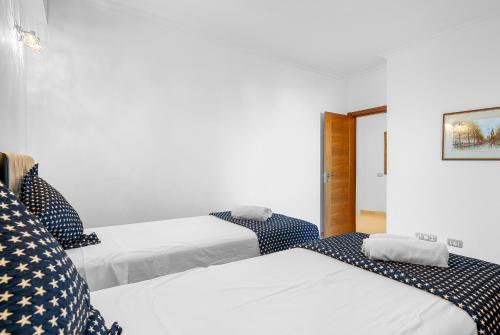 two beds in a room with white walls at Palm Mar Penthouse Duplex in Palm-mar