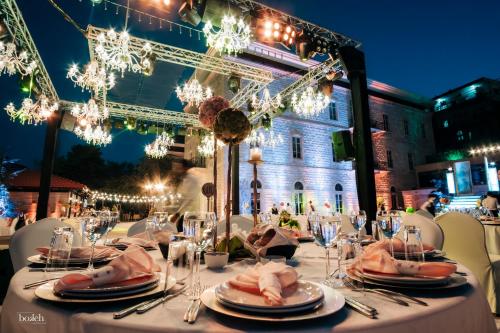 a table set up for a dinner party with lights at Grand Kadri Hotel - History Marked by Cristal Lebanon in Zahlé