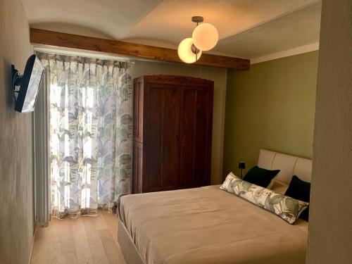 ein Schlafzimmer mit einem großen Bett und einem Fenster in der Unterkunft Cà Trifolera Barbaresco - Cascina vista vigneti con Cantina per degustazioni - Wi-Fi Parcheggio gratuito in Barbaresco
