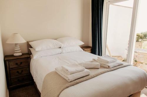 sypialnia z łóżkiem z białymi poduszkami i oknem w obiekcie Little Lodge w mieście Portland