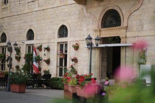 a building with flowers and plants in front of it at Grand Kadri Hotel - History Marked by Cristal Lebanon in Zahlé