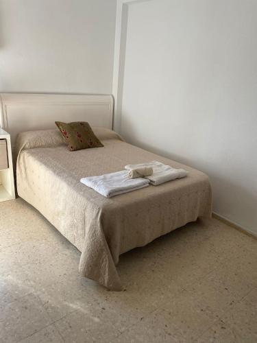 1 cama con 2 toallas en un dormitorio en Habitaciones bonitas, en Mairena del Aljarafe