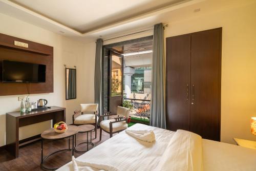 une chambre d'hôtel avec un lit, une table et des chaises dans l'établissement Lime Boutique Bed & Breakfast -Near Eros Hotel Nehru Place Metro, à New Delhi