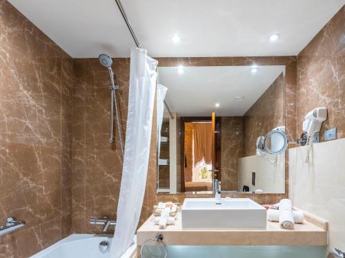a bathroom with a tub and a sink and a bath tub at Grand Kadri Hotel - History Marked by Cristal Lebanon in Zahlé
