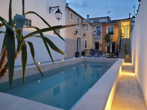 a swimming pool in a house with a building at La Cigale - Piscine - Centre village in Bessan