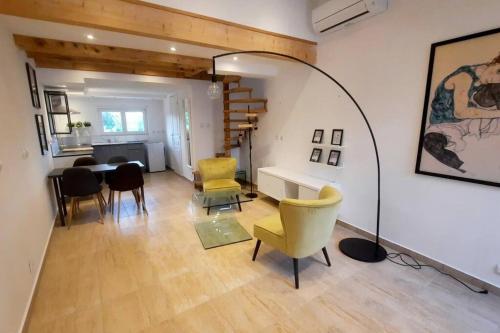 a living room with yellow chairs and a table at La Cigale - Piscine - Centre village in Bessan