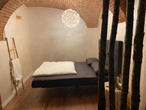 ein Schlafzimmer mit einem Bett in einem Zimmer mit Bäumen in der Unterkunft Borgo di Bagnolo in Villa Barone
