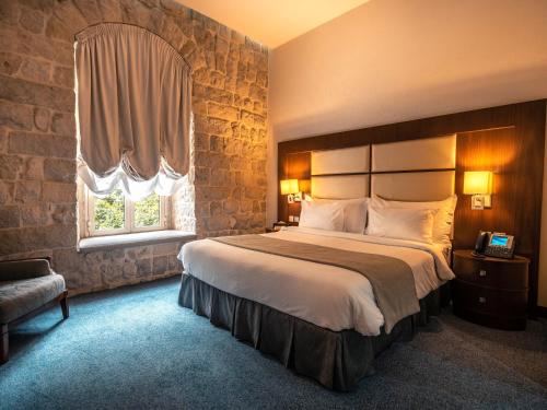 a hotel room with a large bed and a window at Grand Kadri Hotel - History Marked by Cristal Lebanon in Zahlé