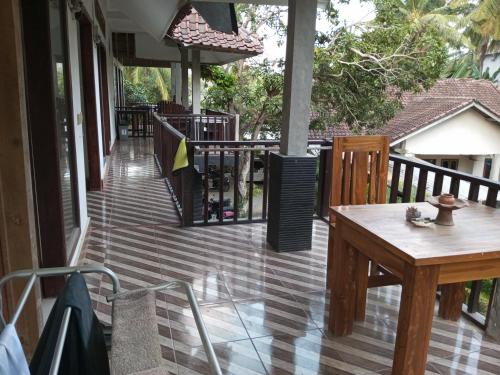 a porch with a table and a fence at Kri Homestay in Kuta Lombok