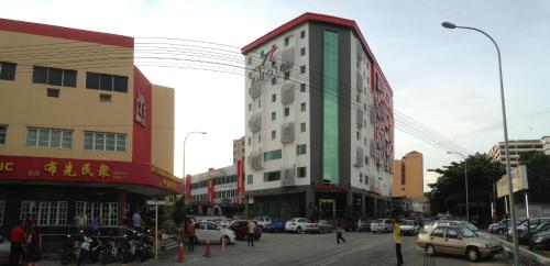 een drukke stadsstraat met auto's en gebouwen bij Hotel Pi Ipoh in Ipoh