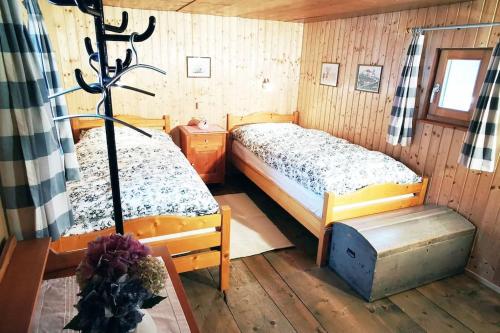 - une chambre avec 2 lits dans une pièce en bois dans l'établissement CHARMANTES FERIENHAUS IM DORF MULEGNS, à Mühlen