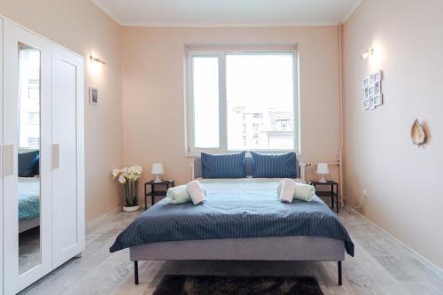 ein Schlafzimmer mit einem Bett und einem großen Fenster in der Unterkunft The Right Choice 2 in Sofia