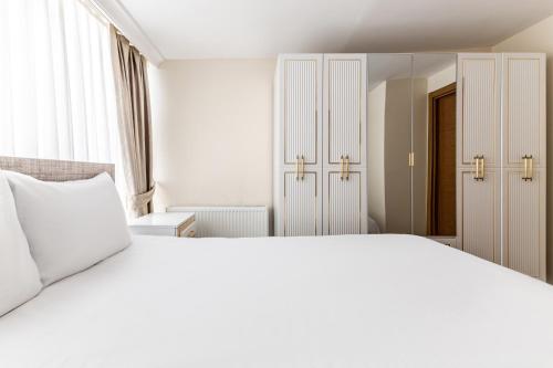 een slaapkamer met een groot wit bed en een spiegel bij Flat with Terrace 1 min to Trump Towers in Istanbul