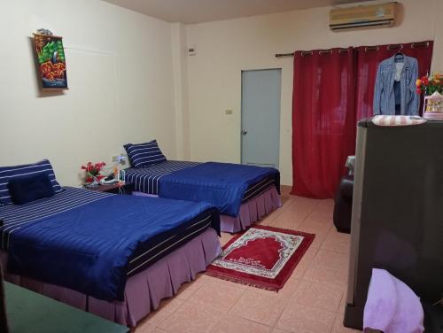 a bedroom with two beds and a red curtain at Pattaya inn By Thai Smile in Pattaya Central