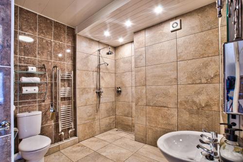 La salle de bains est pourvue d'une douche, de toilettes et d'un lavabo. dans l'établissement Caer Beris Manor By Group Retreats, à Builth Wells