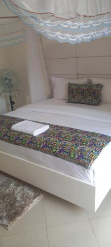 een paar bedden in een slaapkamer met een kleurrijk kussen bij Agnes\ apartments in Kampala