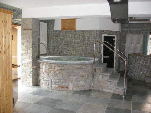 a bathroom with a bath tub in a brick wall at Hotel Savoia Debili in Sauze dʼOulx